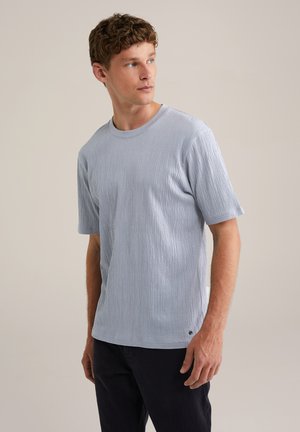 Camiseta de manga corta azul claro hecha de tejido texturizado, con cuello redondo y un sutil detalle de marca en el dobladillo.