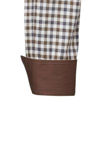 Polsino della camicia a quadri marrone con quadrati bianchi, marroni e blu navy. Presenta un orlo marrone in contrasto. Tessuto in cotone morbido con una superficie liscia.