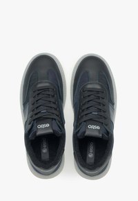 Černé a námořnické tenisky s texturovanou kůží a síťovinovými panely, s modrou nití, kulatými šňůrkami a gumovou podrážkou.