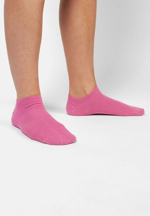 Calcetines de algodón rosa hasta el tobillo con un diseño acanalado y punta sin costuras. Los calcetines cubren el tobillo y tienen una textura suave.