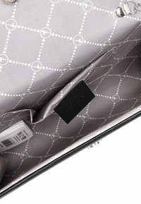 Borsa nera con una texture liscia. L'interno presenta un tessuto grigio con un motivo a griglia bianca e un'etichetta nera. Include slot per carte.