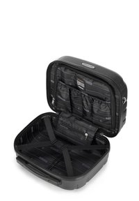 Zwarte harde koffer met textuur; interieur heeft meerdere compartimenten, ritszakken en verstelbare banden.