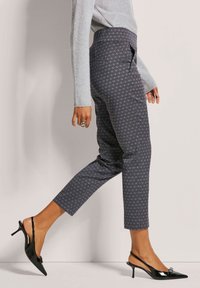 Grijze gestreepte broek met een hoge taille, slim fit en een cropped lengte. Gepaard met elegante zwarte slingback hakken met een kleine accent.