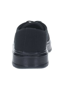 Sneaker en toile noire avec un talon arrondi, une semelle texturée et un laçage élastique. Finition lisse avec des coutures renforcées à l'arrière.