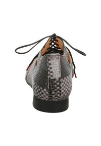 Laced shoe with a black and gray woven texture, featuring a rounded toe and a low black heel; has cutouts and a contrasting interior.