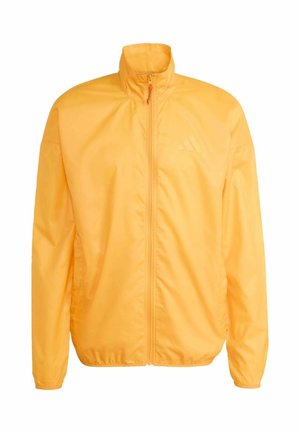 Chaqueta amarilla ligera con cuello alto, cierre completo con cremallera y puños elásticos. Presenta un logo sutil en el pecho y una textura suave.