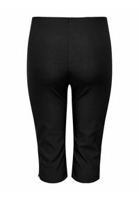 Juodos, iki kelių siekiančios leggings, su glotnia, elastinga tekstūra ir prigludančia forma. Suapvalintas liemuo, be matomų raštų ar metalinių detalių.