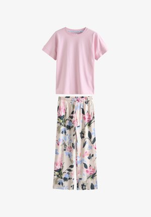 Hellrosa kurzärmeliges T-Shirt kombiniert mit lockeren beigen Hosen mit mehrfarbigem Blumenmuster und Kordelzug in der Taille.