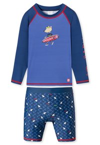 Langærmet blå rash guard med røde accenter; har en tegneserieulv med en surfbræt. Matchende tætsiddende badebukser med fiskemønster i blå.