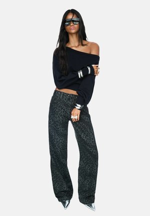 Black off-the-shoulder sweater, leopard print gray pants, silver accessories, and pointed silver heels. Smooth texture and loose fit.