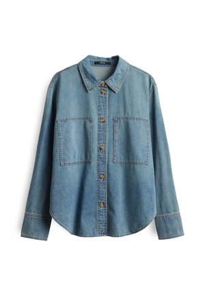 Lichtblauwe denim shirt met een puntige kraag, bronzen knopen, twee grote borstzakken en lange mouwen. Heeft een gebogen zoom.