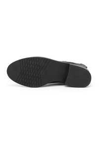 Suola di scarpa in gomma nera con superficie testurizzata, forma arrotondata e un motivo del battistrada ben definito per grip e stabilità.