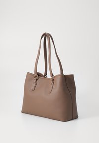 Braune Leder-Tote mit glatter Textur, doppelten Griffen und kleinen Metallelementen. Strukturierte Form mit abgerundeten Ecken.