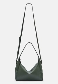 Zielona skórzana torba na ramię z w kształcie litery V, teksturowana powierzchnia, regulowany pasek oraz kontrastujące czarne akcenty.