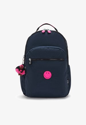Navy fabric backpack with a rounded shape, pink smiley badge, and zippered pockets. Includes a cute fuzzy monkey keychain attachment.