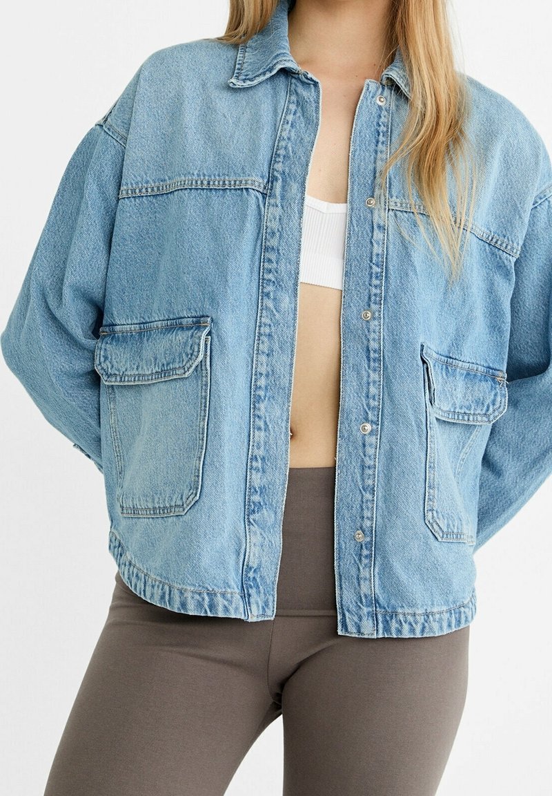Lichtblauwe denimjacket met een relaxed fit, lange mouwen, knoopsluitingen en twee voordockets. Gemaakt van gestructureerd katoenmateriaal.