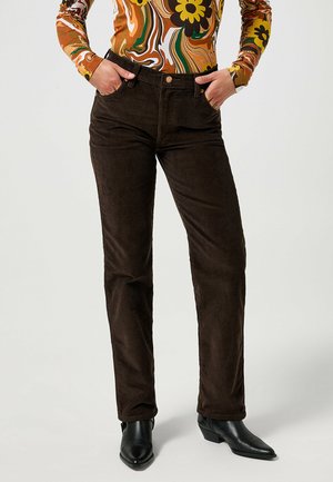 Braune Cordhosen mit schmalem Bund und geradem Bein, die über eine dezente Rippstruktur und klassische Taschenakzente verfügen.