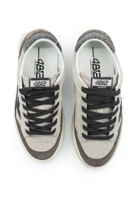 Beige und graue Sneakers aus Wildleder und Leder, mit schwarzen Schnürsenkeln, durchbrochenen Akzenten und einem gemusterten Rückendesign.