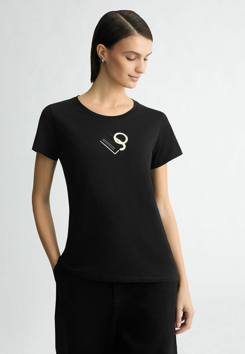 Zwart katoenen t-shirt met een ronde hals en korte mouwen, versierd met een gestileerd, lichtgekleurde grafisch ontwerp op de voorkant.