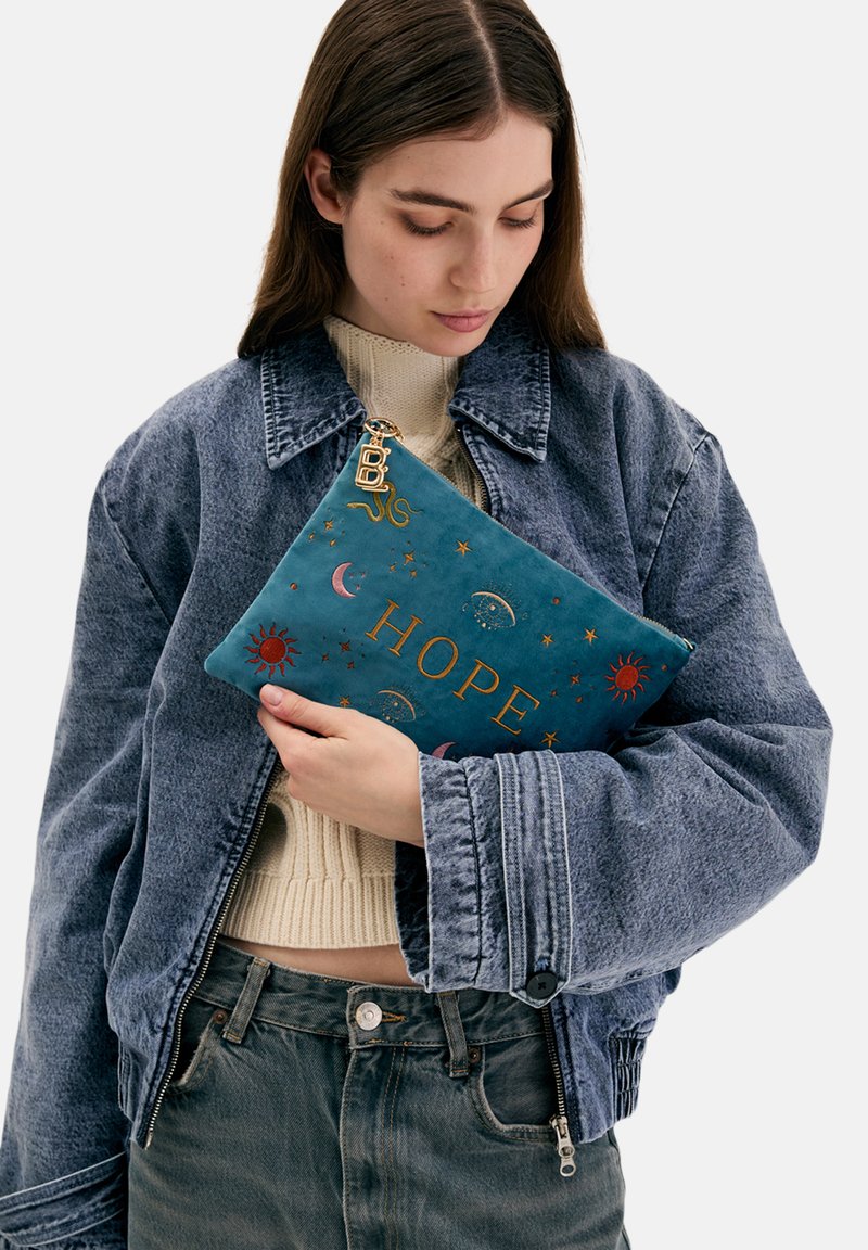 Tyrkysově modré kožené psaníčko s vyšívanými motivy slunce, měsíce a hvězdy; s nápisem "NADĚJE" ve zlatém písmu; obsahuje kovový jezdec na zipu.