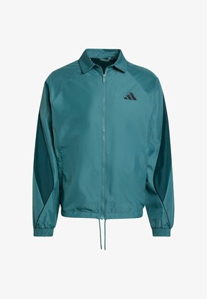 Türkisfarbene leichte Jacke mit Reißverschluss, Stehkragen, elastischen Bündchen und einem schwarzen Logo auf der Brust. Mit kontrastierenden Paneeldetails.