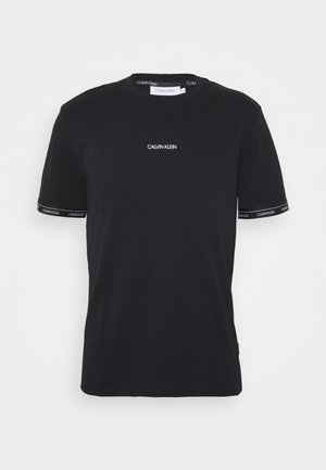 Camiseta negra de manga corta Calvin Klein con logo blanco en el centro del pecho y logo impreso en los bordes de las mangas y en el interior del cuello.