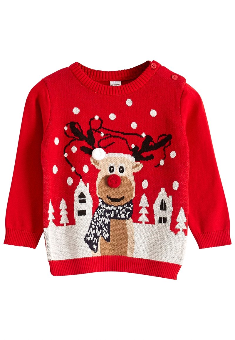 Pull rouge pour enfant avec un renne souriant portant un bonnet de Père Noël et une écharpe, entouré de flocons de neige blancs et de maisons d'hiver.