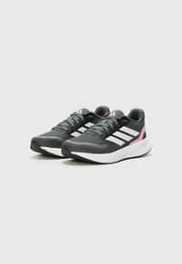 Chaussures de sport noires avec une tige en maille texturée, des rayures blanches, des accents roses et une semelle rembourrée pour le soutien. Design à lacets, légères.