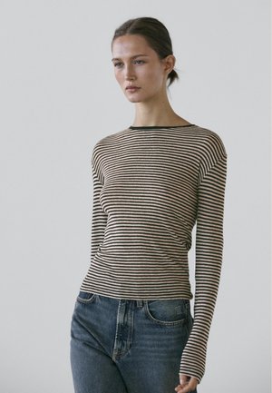 Striped long-sleeve top in beige and black, round neckline, fitted design, made from soft material, paired with blue jeans.