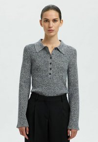 Stickad polo-shirt i grå och marinblå med långärmar, knäppning och krage. Texturerad tyg med ett subtilt prickigt mönster.