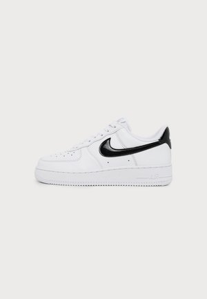 Hvid lavtop sneakers med sort Nike swoosh og hælkappe, hvide snørebånd og perforeringer på tåområdet.