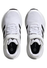 Zapatillas deportivas blancas con detalles en negro, parte superior de malla, diseño de cordones y correa ajustable. Presenta el texto "Fin a los Residuos Plásticos" en el interior.