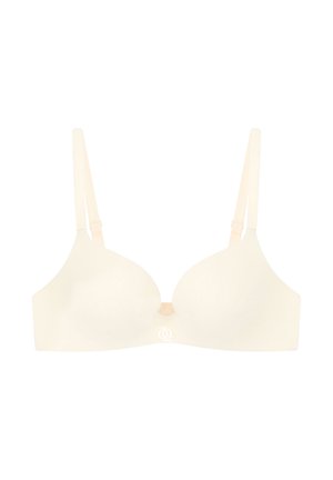 Cream-colored bra with smooth cups, adjustable straps, and a small logo detail at the center. Material appears soft and seamless.