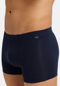 Námořnicky modré boxerky z měkké tkaniny, s úzkým střihem, logem na pasové pásce a plochými švy pro pohodlí.