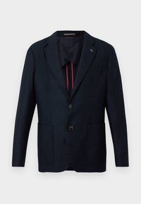 Blazer navy con diseño de un solo botón, dos bolsillos frontales y una tela sutilmente texturada. Forrado con un detalle de color contrastante.