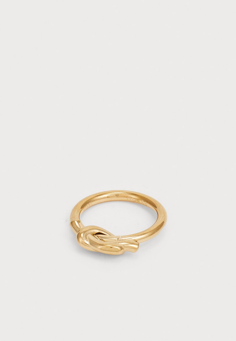 Gold ring featuring a smooth band and a knot detail on one side, showcasing a sleek finish and polished texture.
