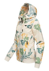 Blomster-mønstret hættejakke i cremefarvet, med grønne, gule og blå blomster. Lynlåslommer og ribbede manchetter. Glat, let materiale.