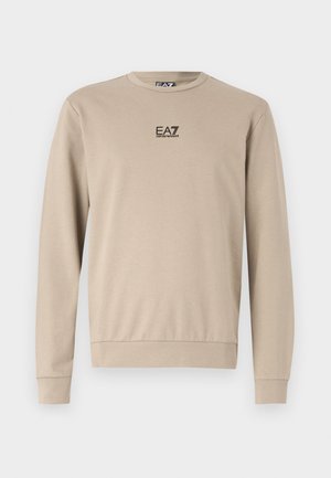 Felpa beige a maniche lunghe con scollatura rotonda, polsini e orlo a coste, che presenta un piccolo logo nero sul petto. Tessuto morbido.