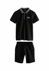 Set di polo nera e pantaloni corti. La polo presenta un colletto con motivo geometrico, chiusura con zip e logo; i pantaloni corti hanno una vita elastica e tasche.