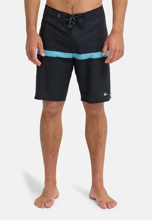 Czarne kąpielówki z jasnoniebieskim poziomym paskiem, wykonane z fakturowanej tkaniny i z zapięciem na sznurowadła z przodu. Logo na dole po lewej stronie.