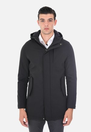Parka nera con cappuccio, dotata di una chiusura frontale con zip, due tasche laterali e una tasca sul petto. Tessuto liscio con finitura opaca e design minimalista.