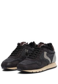 Schwarze Sneaker aus einer Kombination von Wildleder und Wollfilz, mit einem strukturierten grauen Seitenelement und schwarzen Schnürsenkeln.