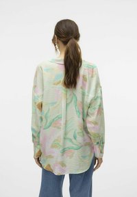 Camicia leggera a motivi pastello con maniche lunghe, vestibilità rilassata, una piega sul retro e una texture sottile. Colletto sovrapposto e polsini con bottoni.