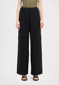 Pantalons cargo noirs à jambes larges avec une taille élastique, dotés de deux poches avant et d'un tissu lisse et léger. Design à l'avant plat.
