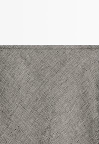 Szary materiał o fakturze z wzorem w kratkę i pojedynczy szew biegnący poziomo w pobliżu górnej krawędzi.