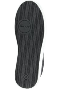 Czarna gumowa podeszwa buta z falistym wzorem bieżnika, białe wykończenie, logo GANT na środku, rozmiar wybity jako 37.