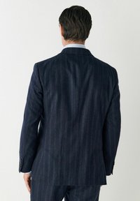 Tengerés pinstripe zakó olivás textúrával, hátán egy nyílással és elegáns hajtókákkal. Részletként három gomb található az ujjakon.