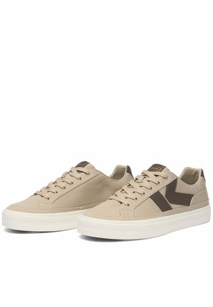Coppia di sneaker beige basse con suole bianche e accenti marroni a chevron sui lati, con lacci e etichetta brandizzata sulla linguetta.