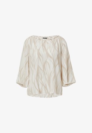 Blouse beige avec un motif de feuilles, fabriquée en tissu léger. Elle dispose d'un décolleté large et de manches ballon.