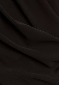 Tessuto nero con una superficie liscia e opaca, caratterizzato da morbide pieghe e drappeggi, che sottolineano la sua natura leggera e flessibile.